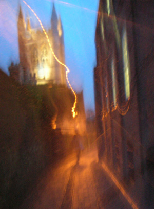 Figure approaching St Andrews Church, Farnham, November twilight.