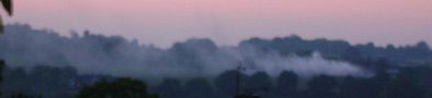 barn on fire at sunset across valley